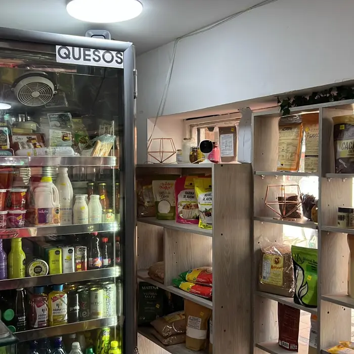 Interior de La Veganistería: la nevera de quesos y los estantes de despensa